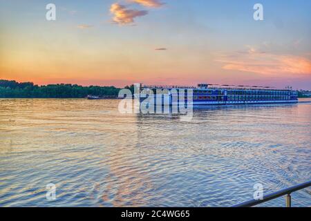 Wunderschöne Sonnenuntergangsansicht des Passagierschiffs, das auf der Donau segelt. Stockfoto