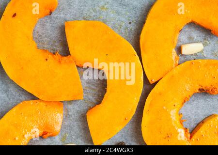 Helle Kürbisscheiben, die zum Backen im Ofen vorbereitet werden. Stockfoto