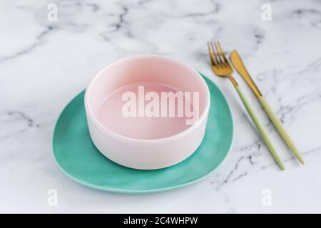 Elegante Tischunterlage mit farbenfrohen Keramikplatten auf weißem Marmorboden Stockfoto