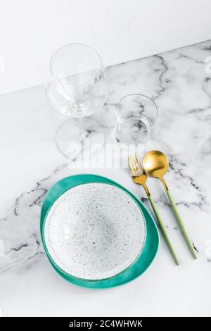 Elegante Tischunterlage mit Keramikplatten auf weißem Marmorboden Stockfoto