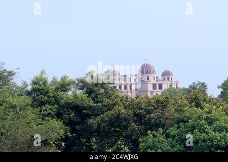Historisches Gebäude ist sichtbar hinter dem grünen Baum mit Natur, Hintergrund Bild, selektiver Fokus. Stockfoto