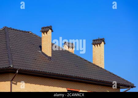 Ein Dach einer keramischen Fliese mit Belüftung durch ein Rohr ein Sturmabflusssystem, schließen Details der architektonischen Struktur.. Stockfoto