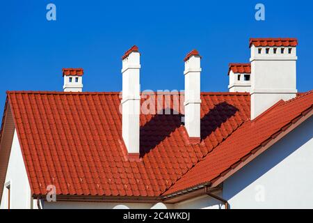 Ein orangefarbenes Dach einer Keramikfliese mit Belüftung durch ein Rohr ein Sturmdrainage-System, schließen Details der architektonischen Struktur an sonnigen Tag. Stockfoto