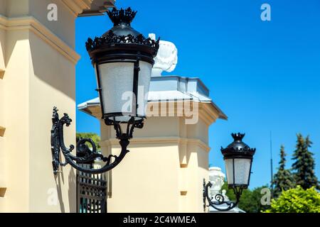 Schwarze schmiedeeiserne Lampen, die am Turm am Eingang des Tores angebracht sind. Stockfoto
