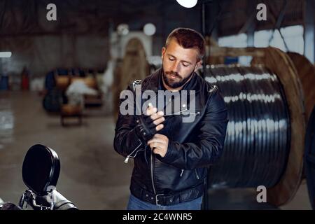 Biker Mann zieht seine Lederhandschuhe zum Reiten Stockfoto
