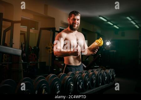 Mann im Fitnessstudio mit Shaker Stockfoto