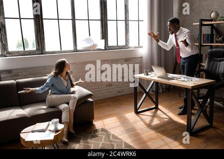 Partner streiten am Arbeitsplatz und stimmen dem Dokument nicht zu. Stockfoto
