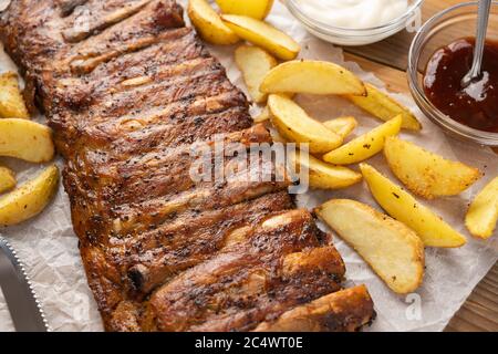 Gekochte Schweinefleischrippen mit pommes Frites mit Grill und Knoblauchsoßen und Bier Stockfoto