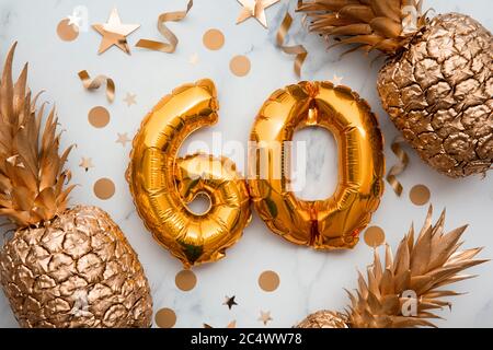 60. Geburtstag-Karte mit goldenen Folienballons und goldenen Ananas Stockfoto