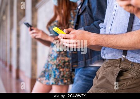 Gruppe von multirassischen Freunden vor einer Wand, die Smartphones verwenden, um Inhalte in sozialen Netzwerken zu teilen Stockfoto