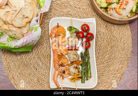 Gegrillte Meeresfrüchte und Gemüse mit Brot und asiatischen Salat serviert Stockfoto