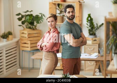 Taille up Porträt von zwei erfolgreichen Unternehmer stehen zurück zu Rücken, während sich selbstbewusst im Büro posieren, kopieren Raum Stockfoto