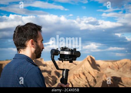 Junge Filmemacherin filmt Naturlandschaft in Canyon mit einem großen Fluss und Sümpfen Stockfoto