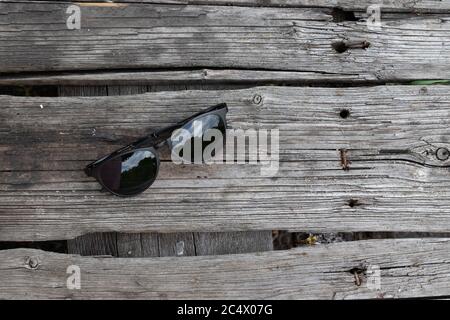 Draufsicht der Sonnenbrille auf Holztisch mit Kopierraum. Stockfoto