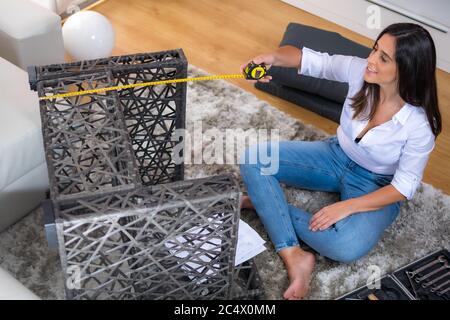 Junge Frau Montage Sessel Möbel in häuslicher Einrichtung Stockfoto