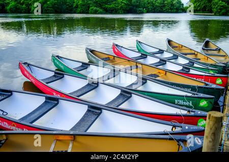 Bunte Kanus und Kajaks festgemacht und gebunden an einem hölzernen Ponton in Salhouse Broad in den Norfolk Broads Stockfoto