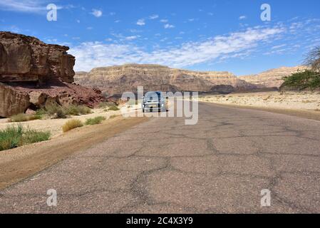 TIMNA, ISRAEL - APR 3, 2015: Auto mit Touristen auf der Asphaltstraße im Timna Nationalpark in der Negev Wüste. Eine von den beliebtesten Naturattraktionen Stockfoto