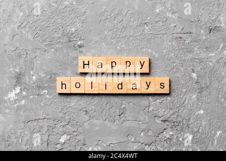 Frohe Feiertage Wort auf Holzblock geschrieben. Happy Holidays Text auf Zementtisch für Ihr Design, Konzept. Stockfoto