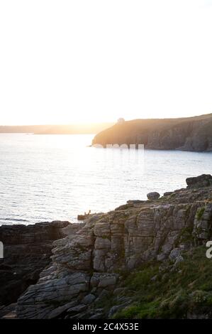 Beobachten des Sonnenuntergangs in Rinsey, Cornwall, Großbritannien Stockfoto