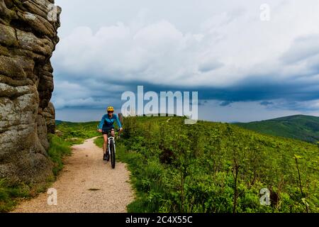 Radfahrerin auf mtb-Fahrrad auf Schotterbergstraße, Beskidy, Polen. Stockfoto