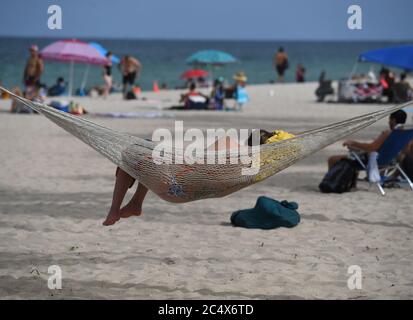 FORT LAUDERDALE, FL - JUNI 28: Eine Frau auf dem Schlafen auf einer Hängematte in Fort Lauderdale Beach gesehen als South Florida Strände sind für Juli schließen 4. Wochenende, Florida berichtet einen weiteren Rekord Spitze in Coronavirus Fällen, Floridas Covid-19 Anstieg zeigt, dass der Staat Wiedereröffnungsplan funktioniert nicht am 28. Juni 2020 in Fort Lauderdale Beach, Florida. Quelle: Mpi04/MediaPunch Stockfoto