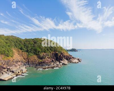 Schöner geheimer Strand Butterfly in Goa, Indien. Luftaufnahme des unberührten Strandes mit felsigen Bucht und Wellen, die zusammenbrechen. Stockfoto