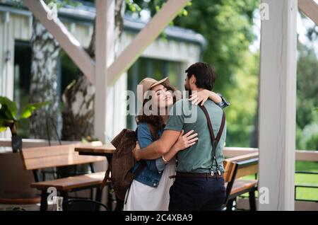 Ein glückliches Paar begrüßt draußen auf der Terrasse, Ende der Sperre. Stockfoto