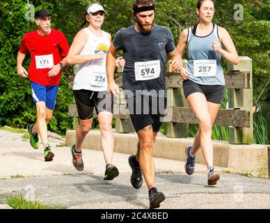 Babylon, New York, USA - 12. August 2018: Eine Gruppe von Läufern läuft die Dirty Sock 10K an einem heißen Sommermorgen, als sie die Fischerbrücke in Sou überqueren Stockfoto