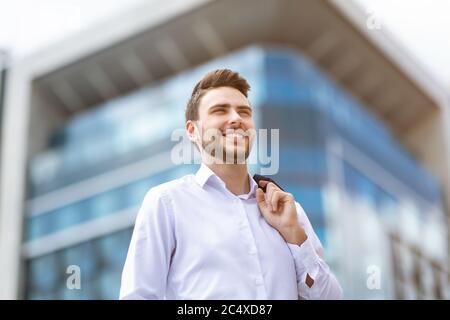 Porträt des glücklichen jungen Geschäftsmann auf der Straße der Großstadt Stockfoto