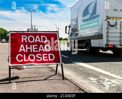 Lieferwagen, der eine Straße vor dem geschlossenen Warnschild, Schottland. Stockfoto