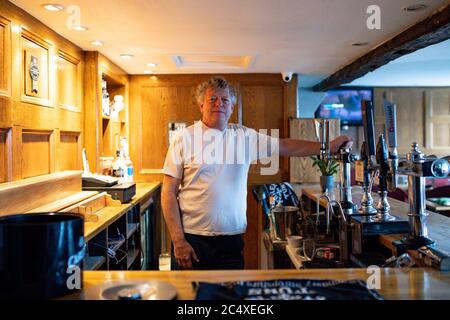 John Turner, Vermieter des Dolphin Pub in Llanymynech, wo die Grenze nach England und Wales entlang der A483 verläuft. Trinklokale auf einer Seite der A-Straße wie die Cross Keys und die Bradford Arms werden am Samstag, den 4. Juli, Gäste begrüßen, aber das Dolphin, ein Pub Yards innerhalb der walisischen Grenze bleibt geschlossen. Stockfoto