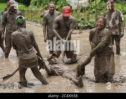 Kathmandu, Nepal. Juni 2020. Nepalesen spielen am 29. Juni 2020 mit schlammigem Wasser auf dem National Paddy Day Festival in Tokha in Kathmandu, der Hauptstadt Nepals. Nepalesen nehmen an Reisplantagen Teil, tanzen und spielen mit schlammigem Wasser während des Festivals, das nach nepalischem Kalender auf ''Asar 15'' fällt. Kredit: Sunil Sharma/ZUMA Wire/Alamy Live Nachrichten Stockfoto