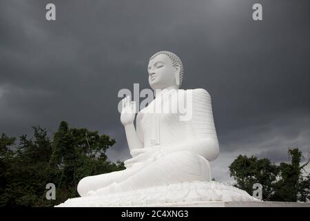 Mihintale, Sri Lanka - UM 2018: Große weiße Buddha-Statue gegen blauen Himmel in Mihintale, der Wiege des buddhismus in Sri Lanka Stockfoto