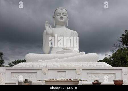 Mihintale, Sri Lanka - UM 2018: Große weiße Buddha-Statue gegen blauen Himmel in Mihintale, der Wiege des buddhismus in Sri Lanka Stockfoto