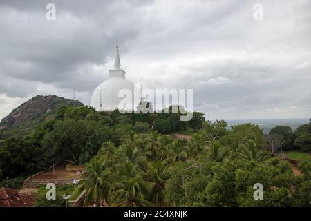 Mihintale, Sri Lanka - UM 2018: Große weiße Buddha-Statue gegen blauen Himmel in Mihintale, der Wiege des buddhismus in Sri Lanka Stockfoto