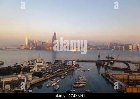 HONGKONG, CHINA - UM 2020: Skyline von Hongkong und Victoria Harbour am Morgen. Sonnenuntergang über der Bucht von Hongkong an einem klaren Tag Stockfoto