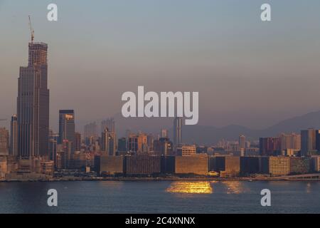 HONGKONG, CHINA - UM 2020: Skyline von Hongkong und Victoria Harbour am Morgen. Sonnenuntergang über der Bucht von Hongkong an einem klaren Tag Stockfoto