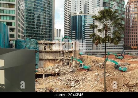 HONGKONG, CHINA - UM 2020: Wolkenkratzer-Bagger, der ein Gebäude in Hongkong demontiert. Riesige Baustelle. Konzept der städtischen modernen Entwicklung s Stockfoto