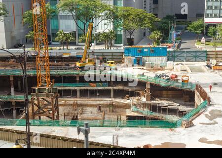 HONGKONG, CHINA - UM 2020: Wolkenkratzer-Bagger, der ein Gebäude in Hongkong demontiert. Riesige Baustelle. Konzept der städtischen modernen Entwicklung s Stockfoto