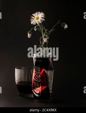 Krasnojarsk, Russland, 20. Juni 2020: Die Kamillenblume wird in eine Coca-Cola-Flasche eingesetzt und als Vase verwendet. Daneben befindet sich ein Glas Cola. Ein Unu Stockfoto