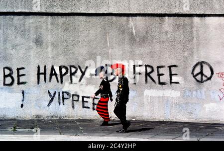 Die Straßenszene eines Teenage Punk Rocker Walking führte einen Slogan CND Graffiti. London England, Großbritannien. Ca. 1980 Stockfoto