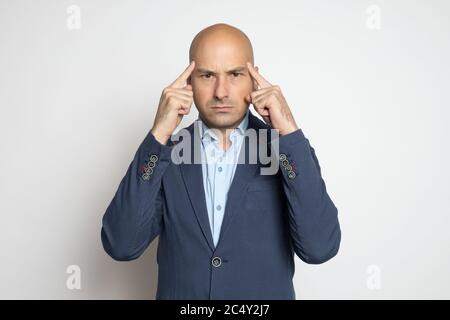 Serious Glatze Mann in blauer Jacke ist hart über Probleme denken Stockfoto