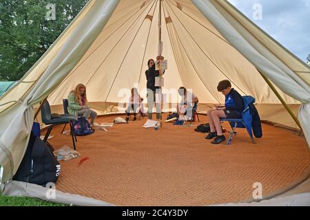 Die Lehrerin Holly Haime unterrichtet die Schüler des fünften Jahrs im Basteln und Basteln, während sie Papierflugzeuge in einem Zelt im Tipi-Stil an der Llanishen Fach Primary School in Cardiff herstellen. Stockfoto