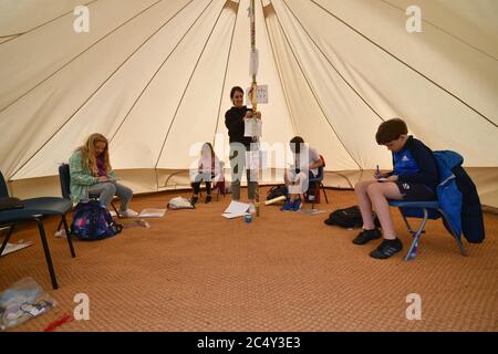 Die Lehrerin Holly Haime unterrichtet die Schüler des fünften Jahrs im Basteln und Basteln, während sie Papierflugzeuge in einem Zelt im Tipi-Stil an der Llanishen Fach Primary School in Cardiff herstellen. Stockfoto