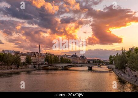 Paris, Frankreich - 28. Juni 2020: Schöne Aussicht auf die seine, die Brücke und den Eiffelturm im Hintergrund bei Sonnenuntergang in Paris. Von Pont des Arts aus gesehen Stockfoto