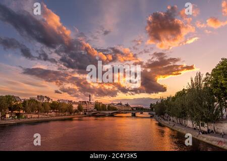 Paris, Frankreich - 28. Juni 2020: Schöne Aussicht auf die seine, die Brücke und den Eiffelturm im Hintergrund bei Sonnenuntergang in Paris. Von Pont des Arts aus gesehen Stockfoto