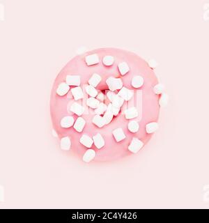 Rosa Donut mit weißen Streuseln auf rosa Hintergrund. Draufsicht, Kopierbereich für Text Stockfoto