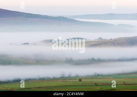 Die Landschaft um Skipton, Yorkshire, wird durch den frühen Morgennebel, der in den Tälern des ländlichen Raums driftet, in mehrere Schichten verwandelt. Stockfoto