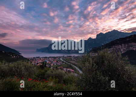 Panoramablick auf den Sonnenuntergang mit dramatisch bewölktem Himmel von Torbole am Gardasee (Gardasee), Trentino, Italien; finanzieller Verlust im Tourismus durch leeres Hotel Stockfoto