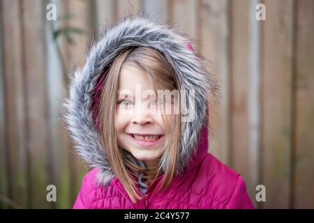 Junges Mädchen trägt rosa Fell Kapuzenjacke Stockfoto